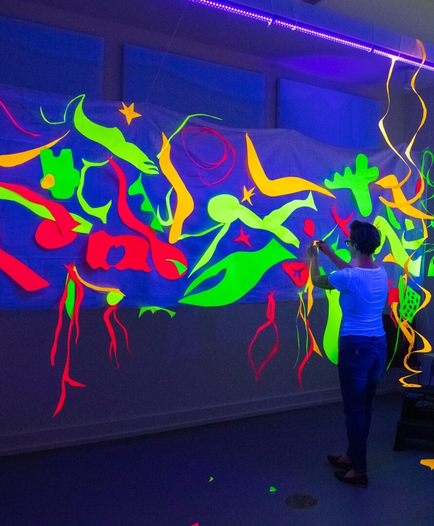 Painting with Scissors – Matisse’s Swimming Pool in black light using glow in the dark paint (Nancy F. Chiasson)